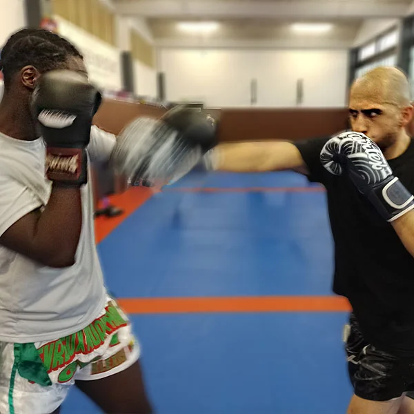 Deux boxeurs face à face : l’un envoie un direct du droit et l’autre le pare avec sa main gauche.