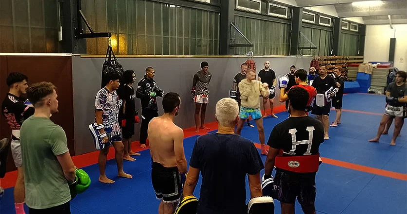 Un groupe de boxeurs entoure l’entraîneur Julien Jourdin, qui fait une démonstration d’un exercice de boxe.